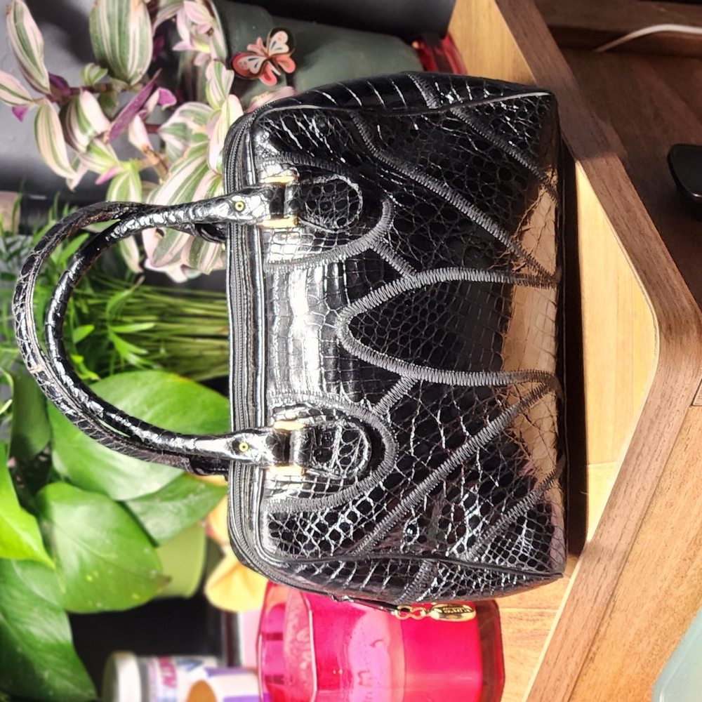 Stylish Black Satchel with Embossed Design and Structured Shape